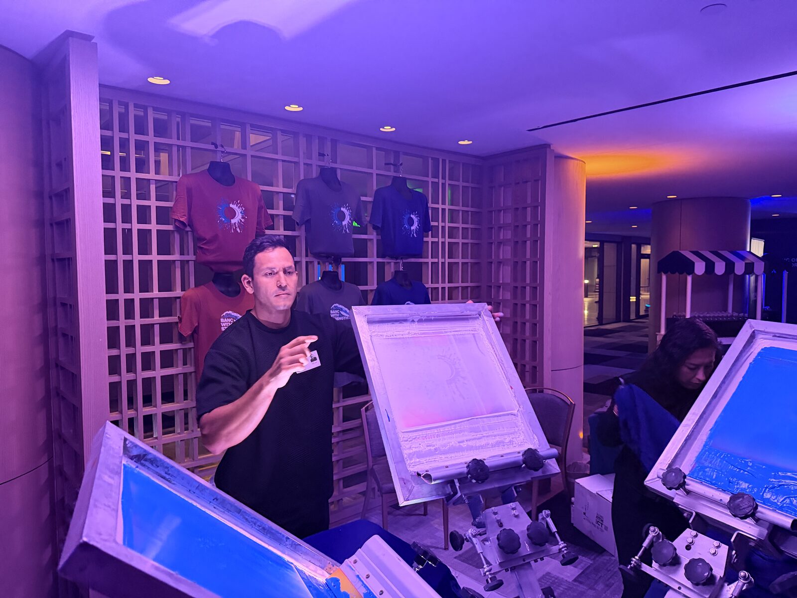 Screen printing presses at night, compared against DTF for live events