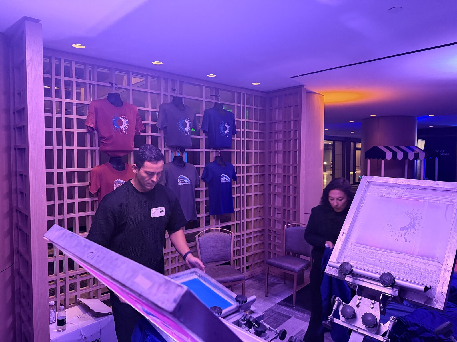 Wall of finished custom event shirts hung after live printing