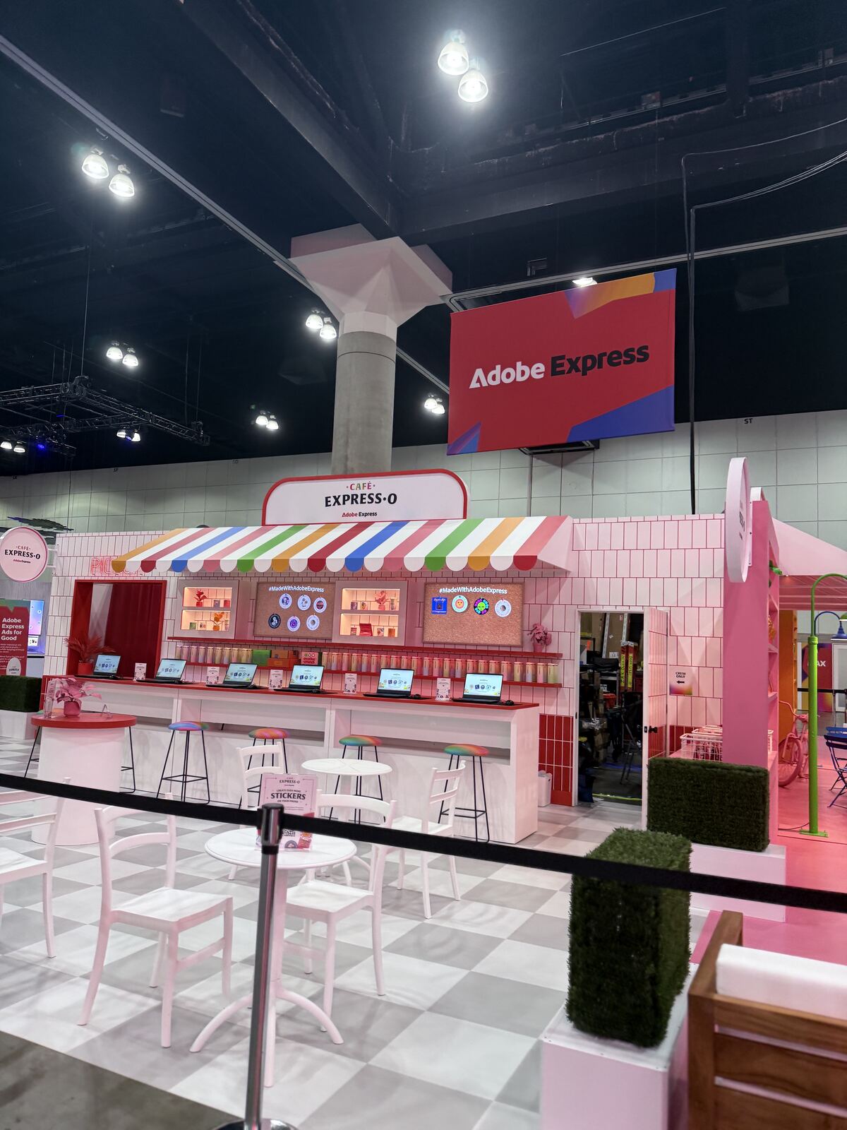 Event venue interior showing a branded booth setup with product displays and attendees interacting